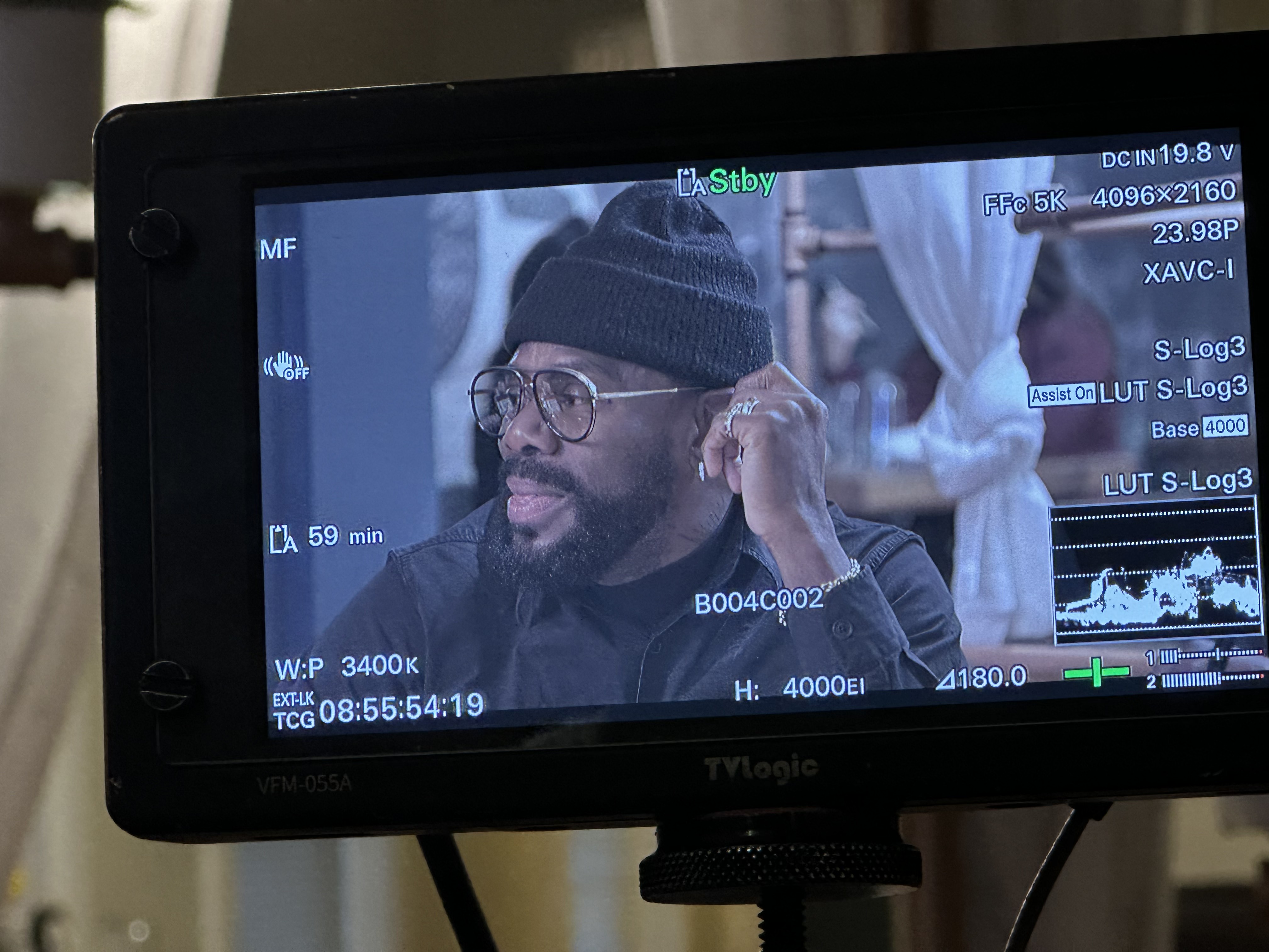 Male talent on a production monitor, groomed with a beard and beanie on set