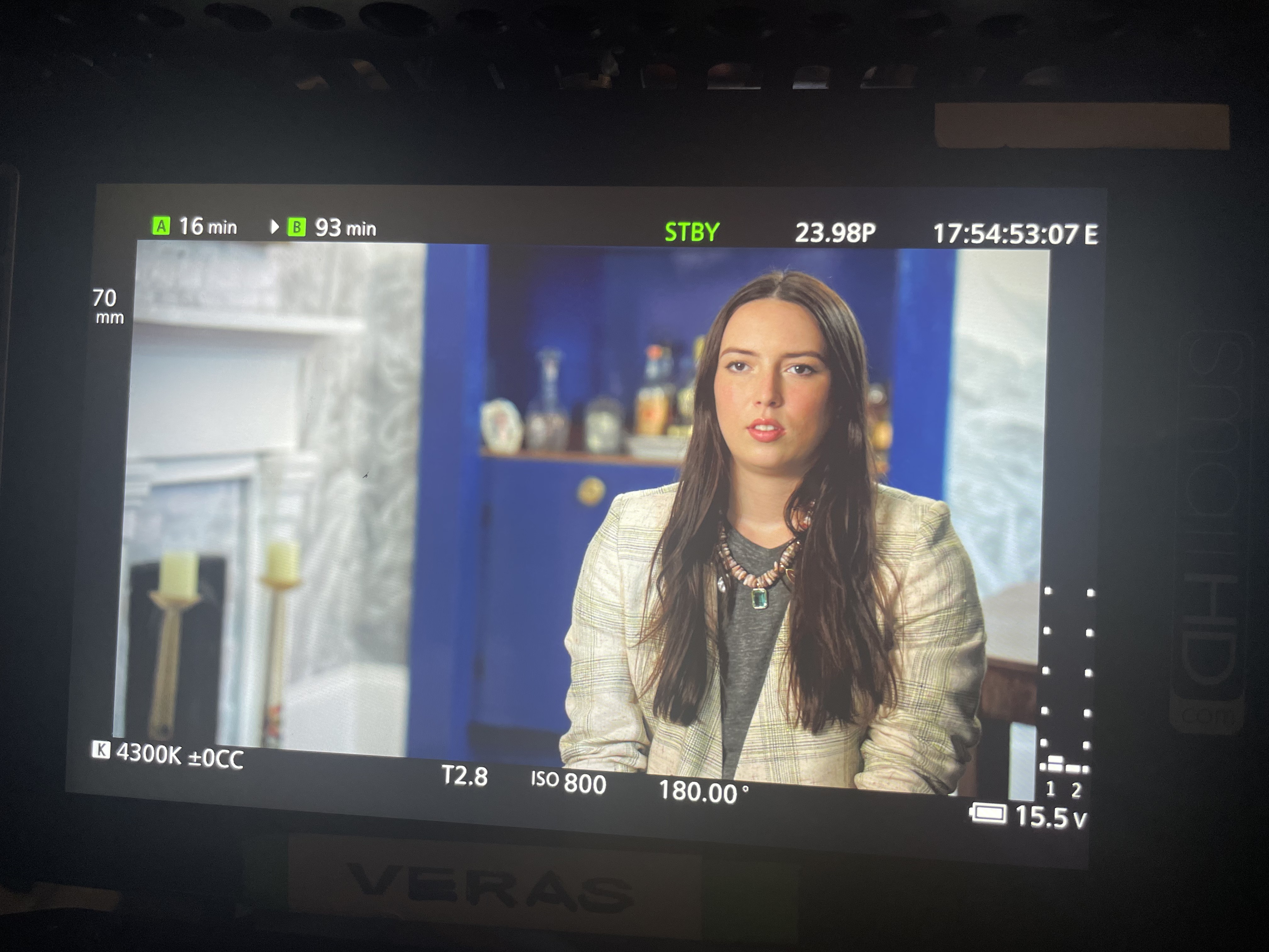 Behind-the-scenes film set moment with talent in warm production lighting