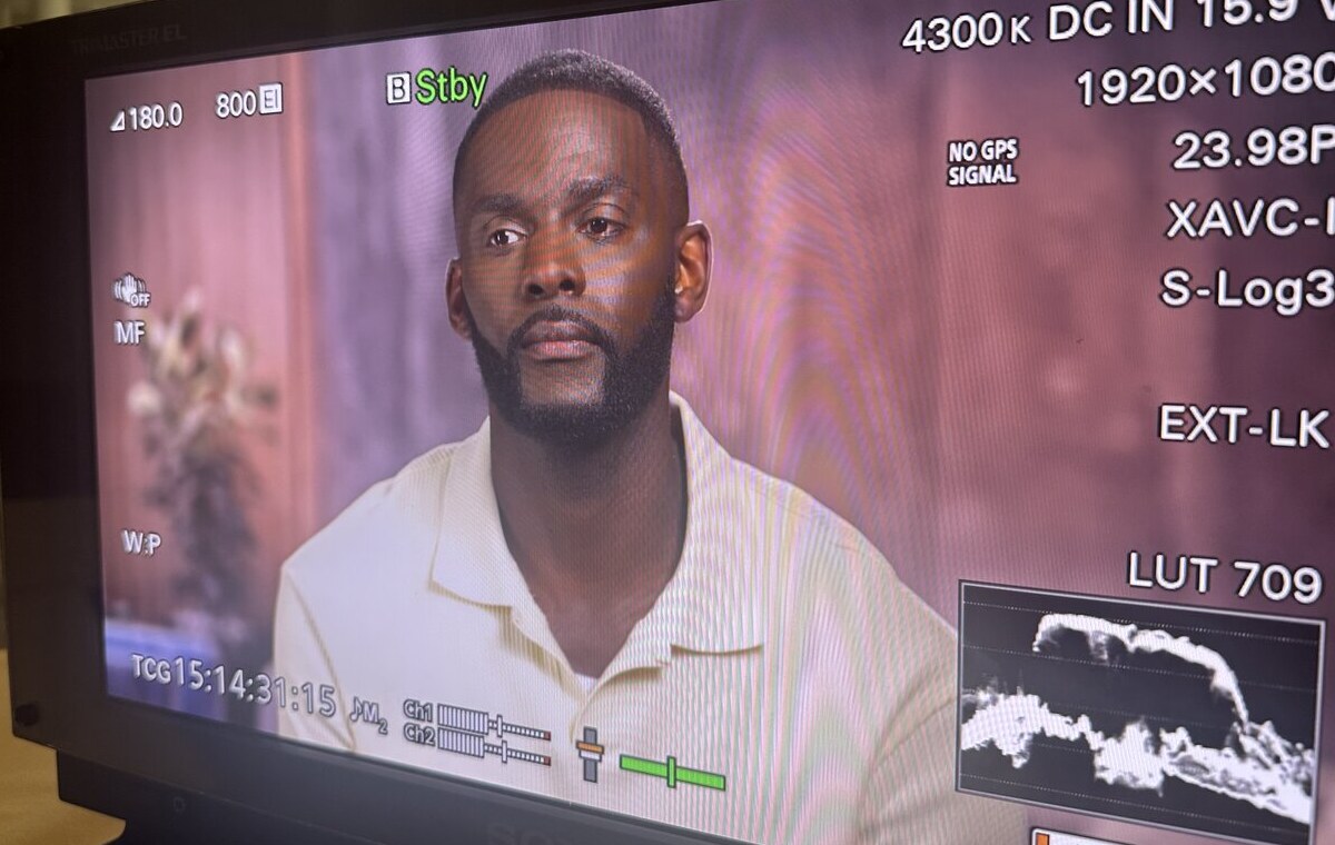 Camera monitor still of male talent groomed for an on-location interview